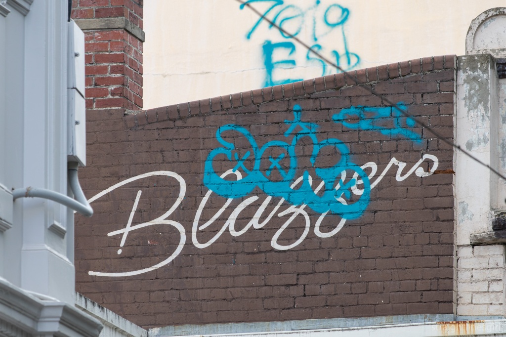 A painted brown brick wall with the work "Blazzers" in white loppy text