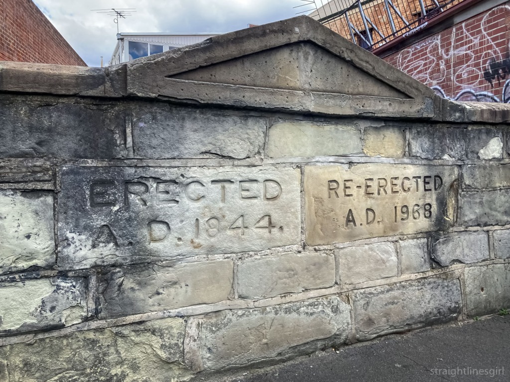 An old stone wall with the words Erected AD 1844; re-erected AD 1968